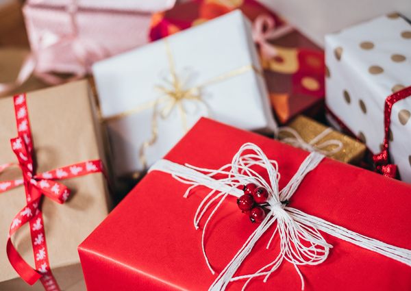 Los mejores regalos de Navidad para él y para ella, a pile of wrapped presents.